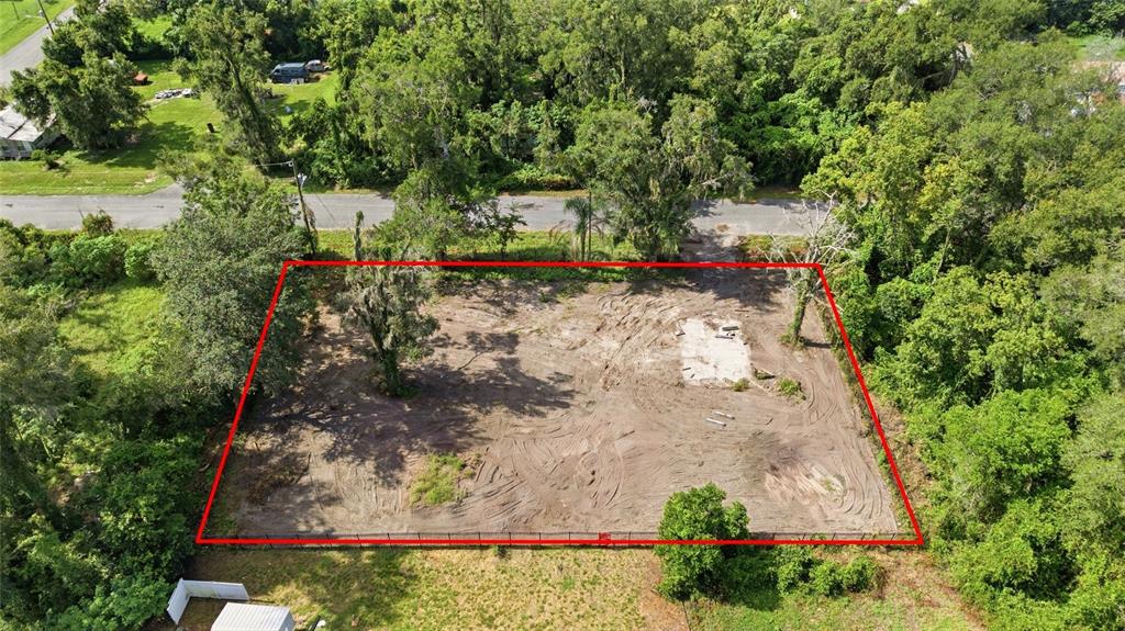 An aerial view of a cleared, rectangular vacant lot bordered by trees and a road — 39211 JARVIS STREET, DADE CITY, FL