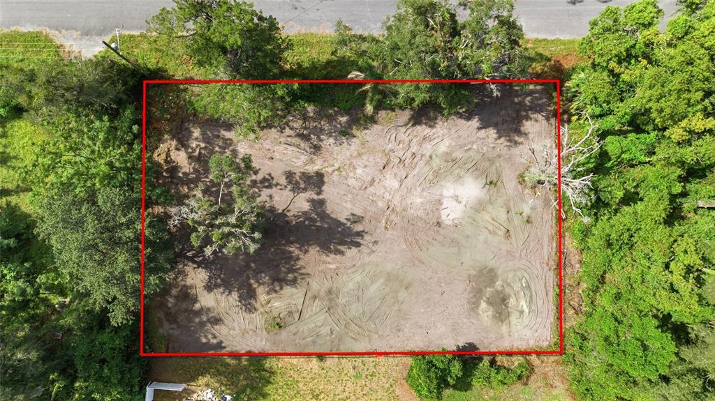 An aerial view shows a rectangular, cleared dirt lot surrounded by trees and vegetation — 39211 JARVIS STREET, DADE CITY, FL