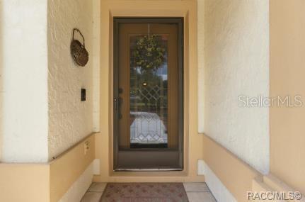 A front entryway features a glass-paneled door with a wreath and a textured wall finish — 5983 W DOUNERAY LOOP, CRYSTAL RIVER, FL