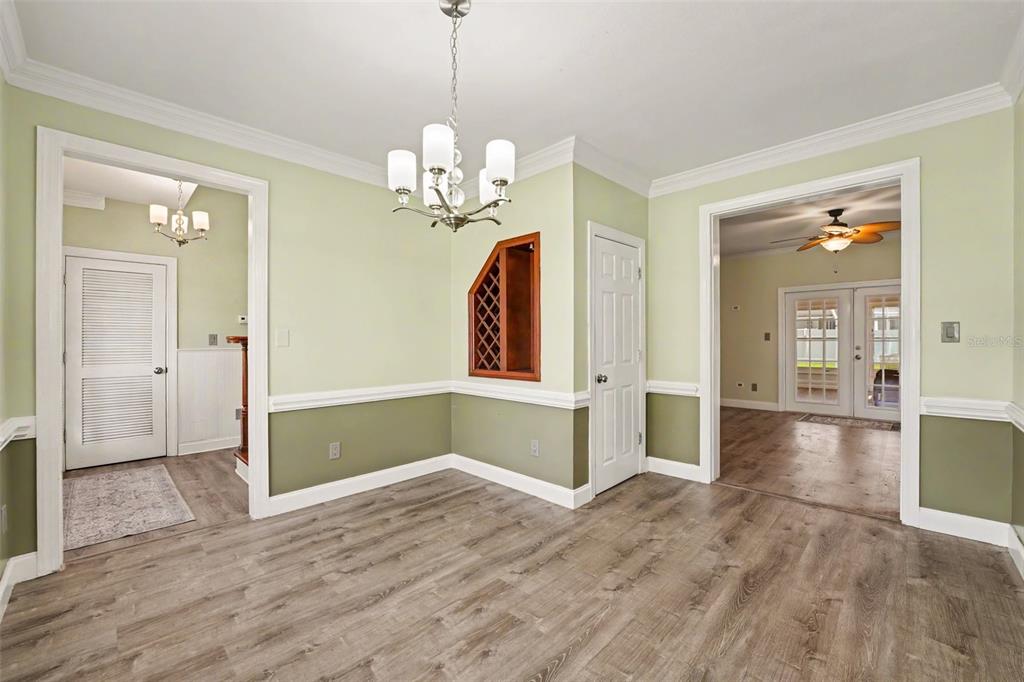 An open-concept living area features wood-look flooring, two ceiling fans, and a modern kitchen — 100 SYLVANA COURT, AUBURNDALE, FL