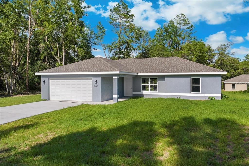 A single-story gray house with a two-car garage and a grassy front yard — 13668 SW 112TH STREET, DUNNELLON, FL