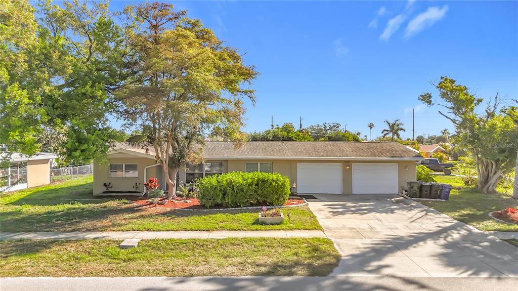 A single-story house with a two-car garage, a large tree, and a concrete driveway — 1521 BANYAN DR., VENICE, FL