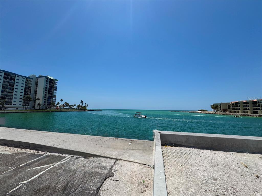 A view of a waterway from a concrete parking area with buildings on both sides — 630 COREY AVENUE, ST PETE BEACH, FL