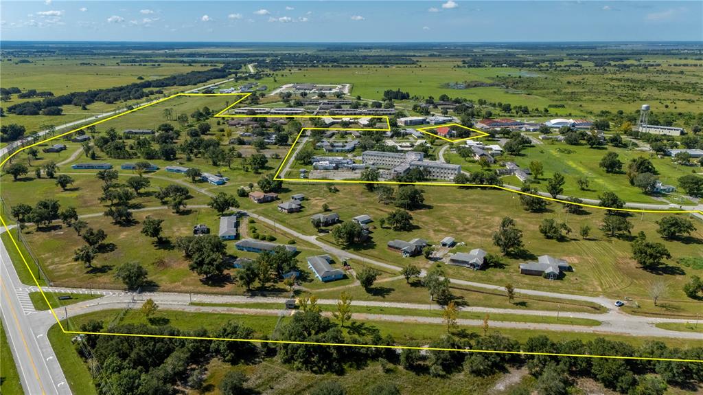 This aerial view shows a large, rural property with multiple buildings outlined in yellow — 6000 SE HWY 31, ARCADIA, FL