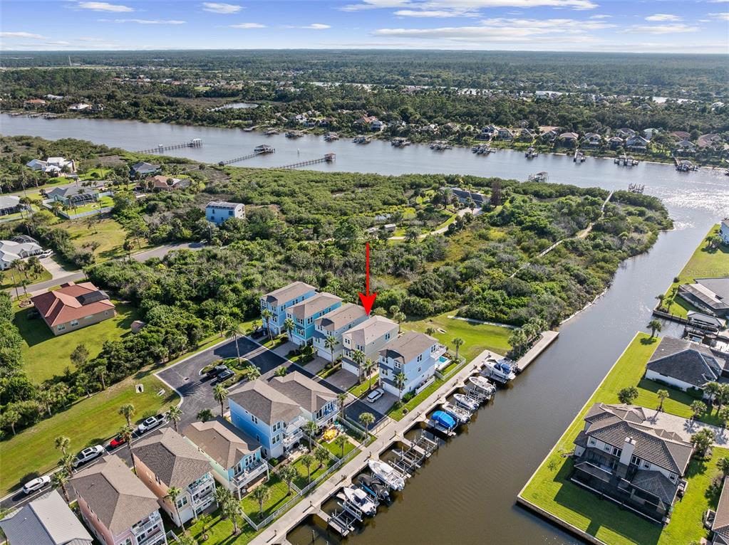 An aerial view shows a row of waterfront townhouses with private boat slips and docks — 2770 MORNING LIGHT COURT, FLAGLER BEACH, FL