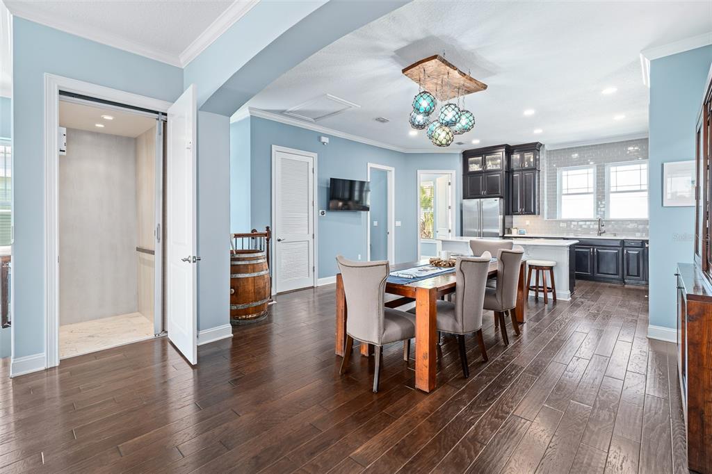 A dining area with a wooden table, upholstered chairs, and an adjacent kitchen with dark cabinets — 2770 MORNING LIGHT COURT, FLAGLER BEACH, FL