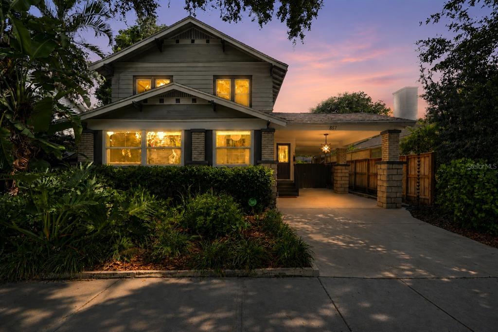 A two-story house with a front porch, carport, and landscaped yard at dusk — 857 21ST AVENUE N, ST PETERSBURG, FL