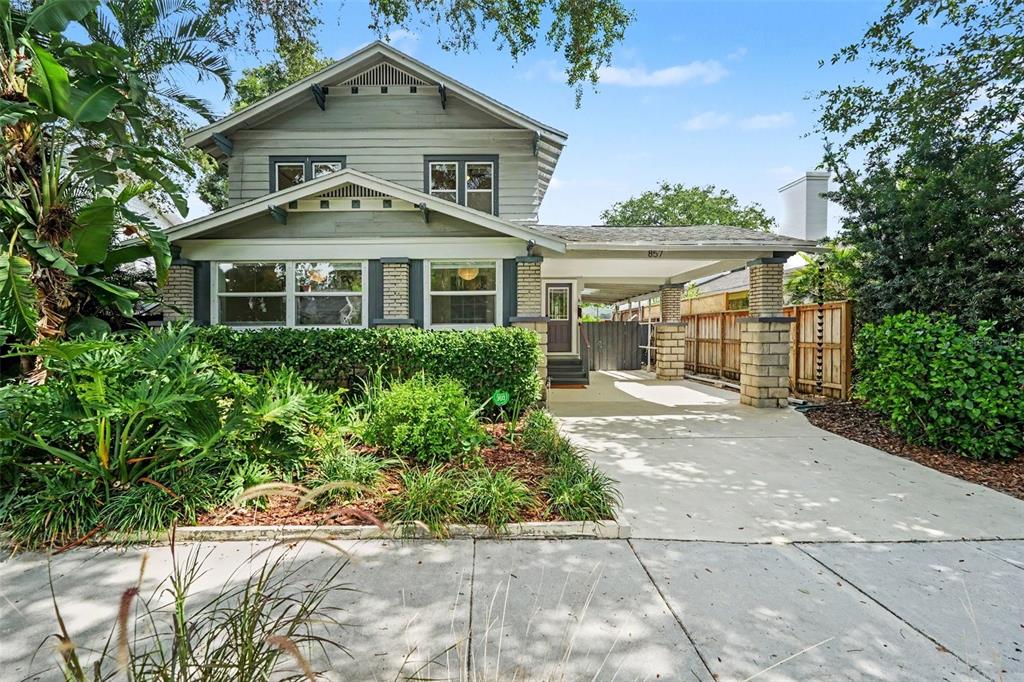 A two-story house with a front porch, a concrete driveway, and lush landscaping — 857 21ST AVENUE N, ST PETERSBURG, FL
