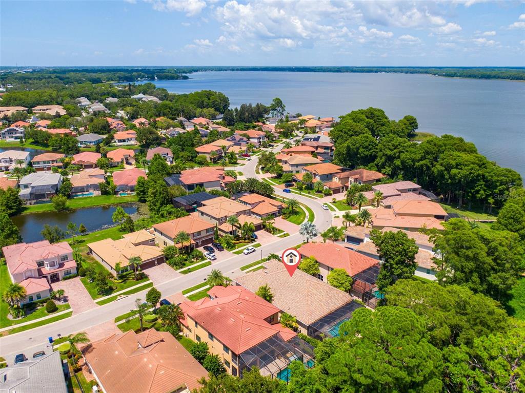 An aerial view shows a suburban neighborhood with houses, a lake, and a red location pin — 2622 GRAND LAKESIDE DRIVE, PALM HARBOR, FL