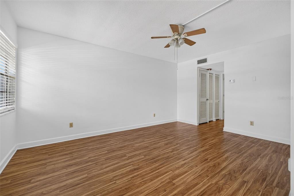 An empty room with white walls, wood-look flooring, and a ceiling fan — 1000 79TH AVENUE N UNIT 111, ST PETERSBURG, FL