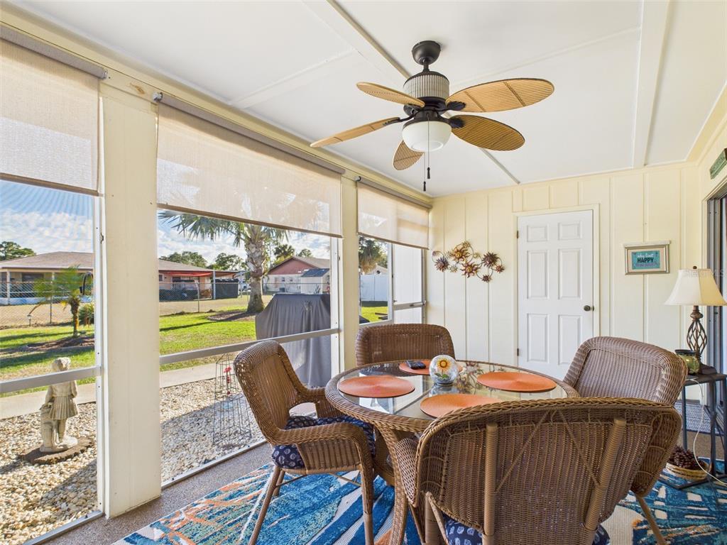 A sunroom features a wicker dining set, a ceiling fan, and views of the yard — 4529 MERCADO DRIVE, SEBRING, FL