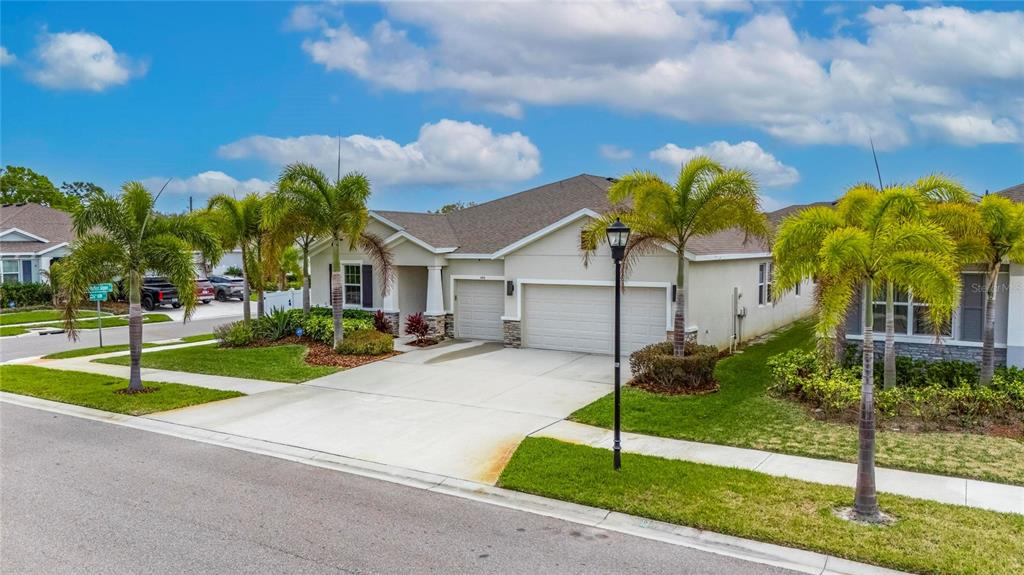 A single-story house with a two-car garage and palm trees in the front yard — 446 6TH AVENUE NW, RUSKIN, FL