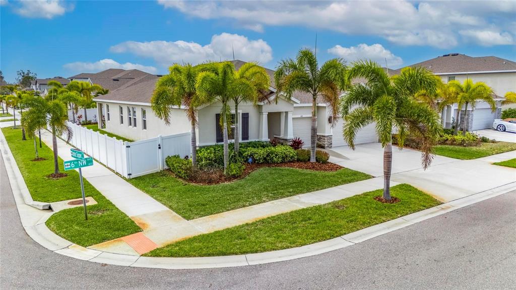 A single-story house with a white fence, palm trees, and a concrete driveway — 446 6TH AVENUE NW, RUSKIN, FL