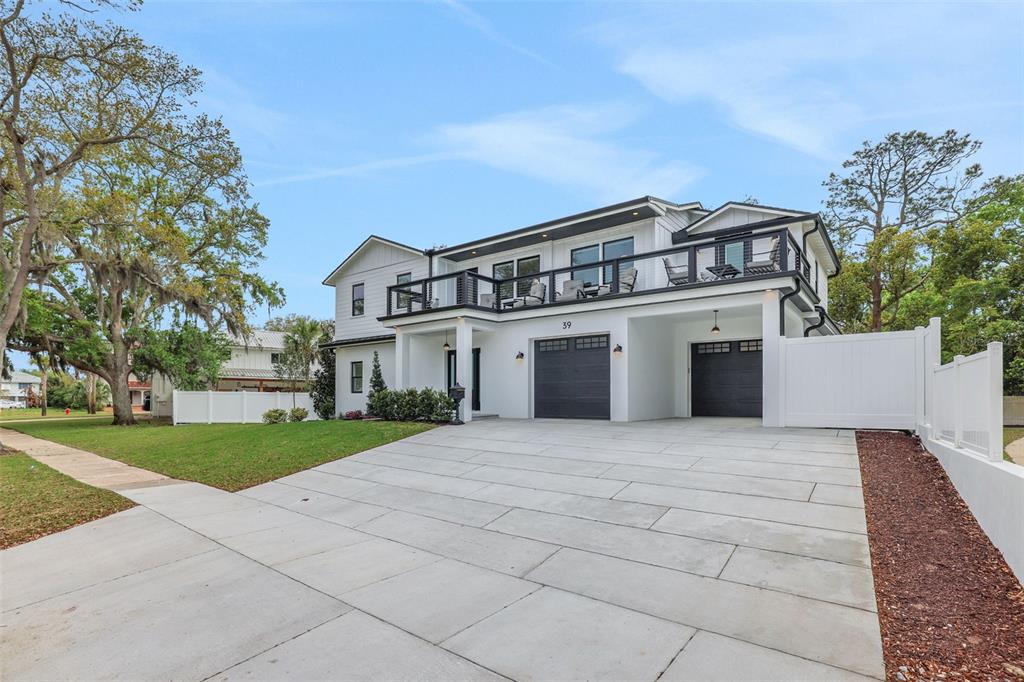 A two-story white house with a black-trimmed balcony and a concrete driveway — 39 E PARK AVENUE, ST AUGUSTINE, FL