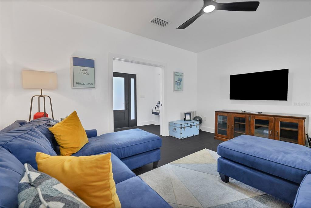 A living room features a blue sectional sofa, a television, and a wooden media console — 39 E PARK AVENUE, ST AUGUSTINE, FL