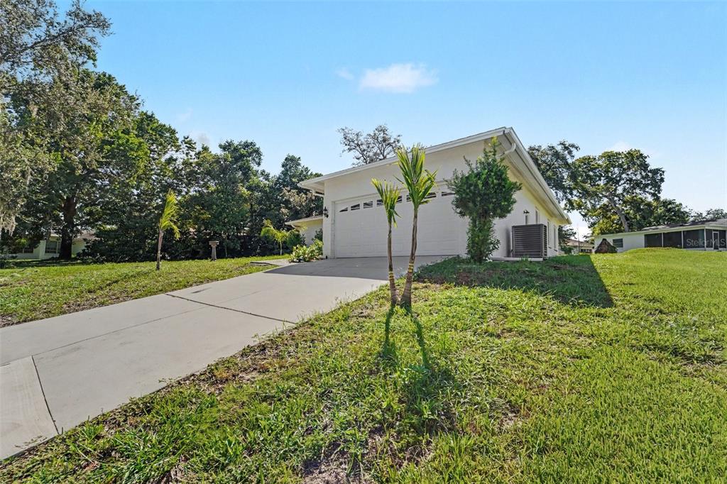 A white single-story house with a two-car garage and a concrete driveway — 8521 CEDARVIEW COURT, PORT RICHEY, FL
