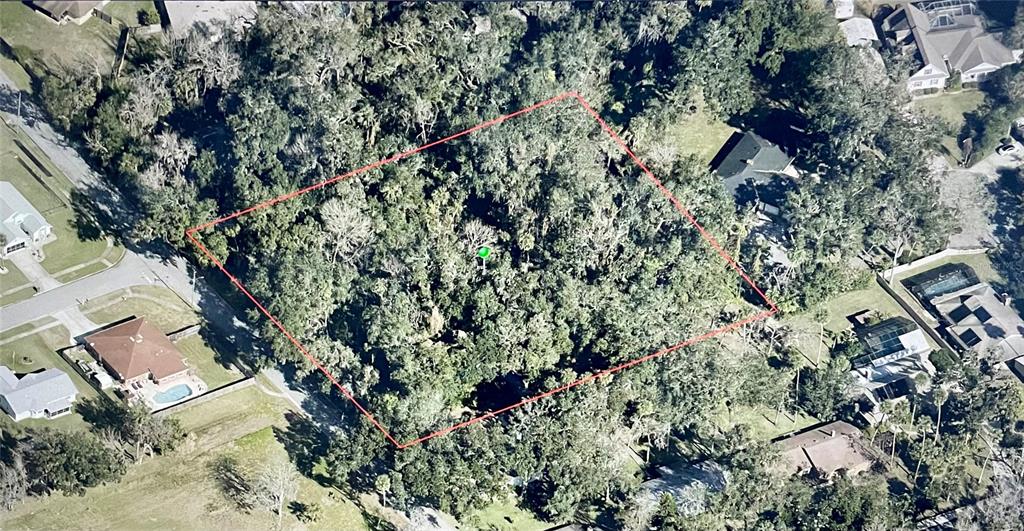 An aerial view shows a rectangular, tree-covered vacant lot outlined in red within a neighborhood — PEPPER HILL ROAD, PORT ORANGE, FL