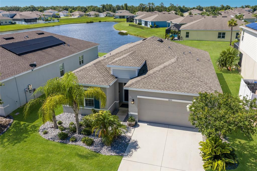 An aerial view of a suburban house with a gray roof and a concrete driveway — 11433 64TH STREET E, PARRISH, FL