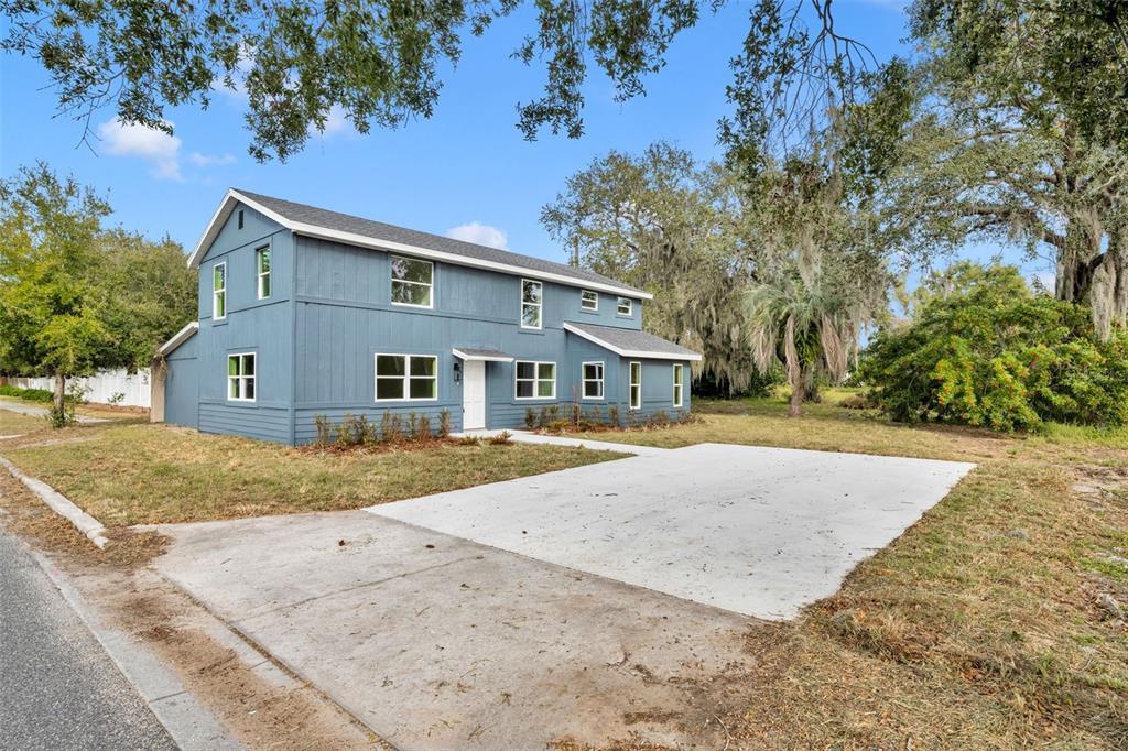 A two-story blue house with a white front door and a concrete driveway — 31201 MERRY RD, TAVARES, FL