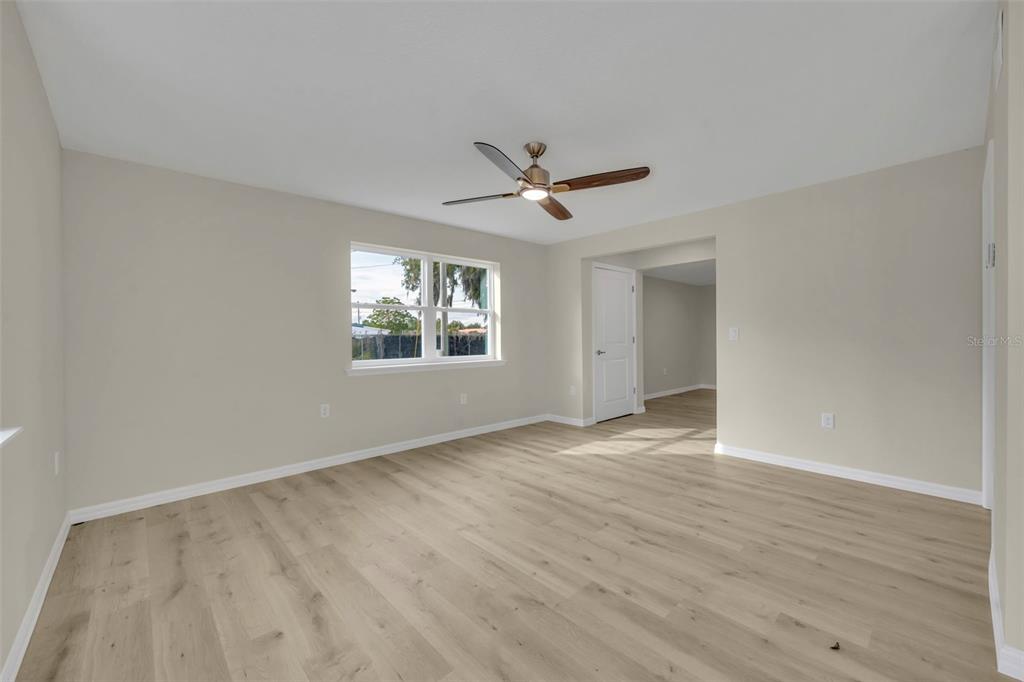 An empty room with light-colored walls, wood-look flooring, a ceiling fan, and a window — 31201 MERRY RD, TAVARES, FL