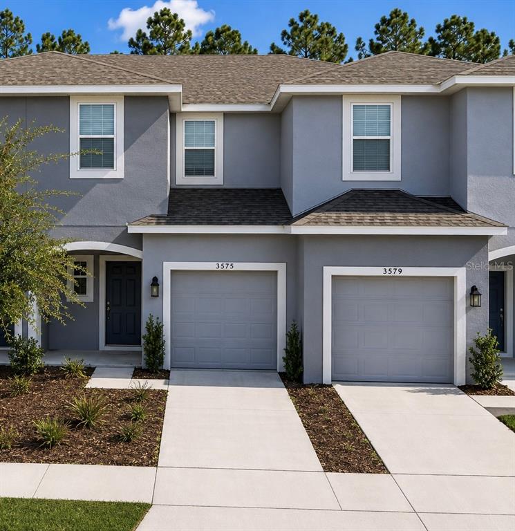 A hallway with wood-look flooring leads toward a living area with sliding glass doors — 3575 DAVENPORT CREEK COURT, KISSIMMEE, FL