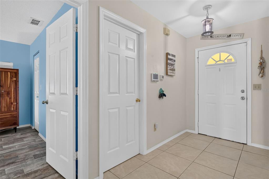 An entryway features tiled floors, white paneled doors, a light fixture, and a front door — 39627 GREENBRIER STREET, EUSTIS, FL