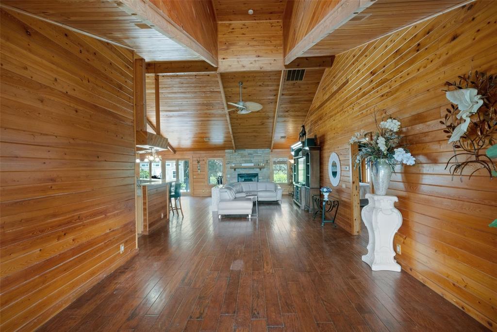 A spacious living area features wood-paneled walls, vaulted ceilings, and dark hardwood flooring — 39730 CARLTON ROAD, PARRISH, FL