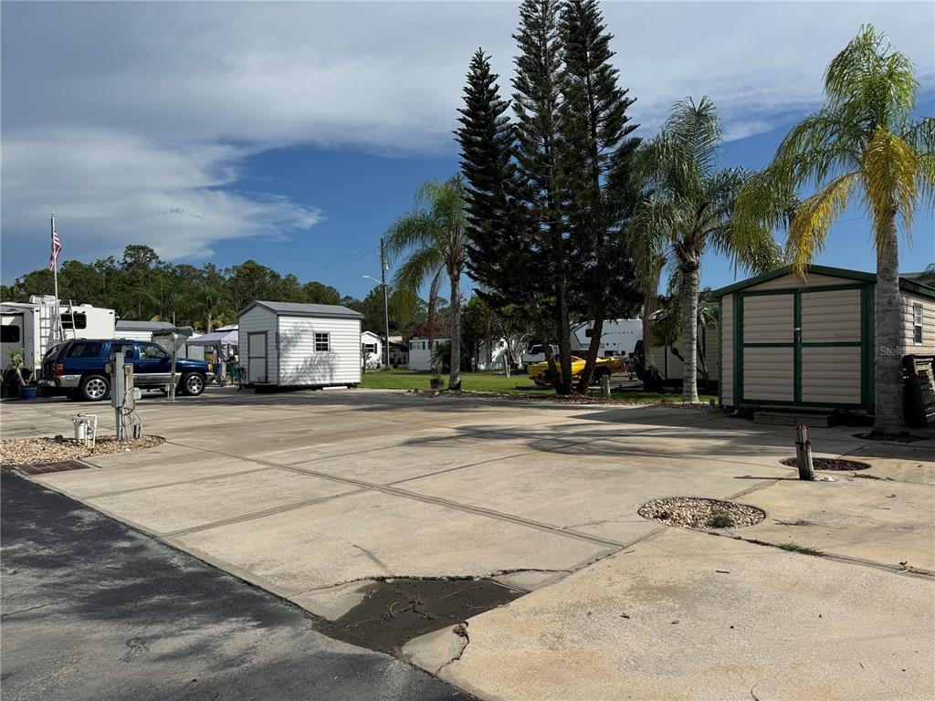 A white Salem travel trailer is parked on a concrete lot with potted plants nearby — 1310 PINE ISLAND DRIVE N, ST CLOUD, FL