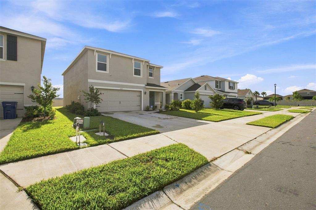 A two-story suburban house with a beige stucco exterior and a two-car garage — 6118 DISTANT HAZE PLACE, PALMETTO, FL