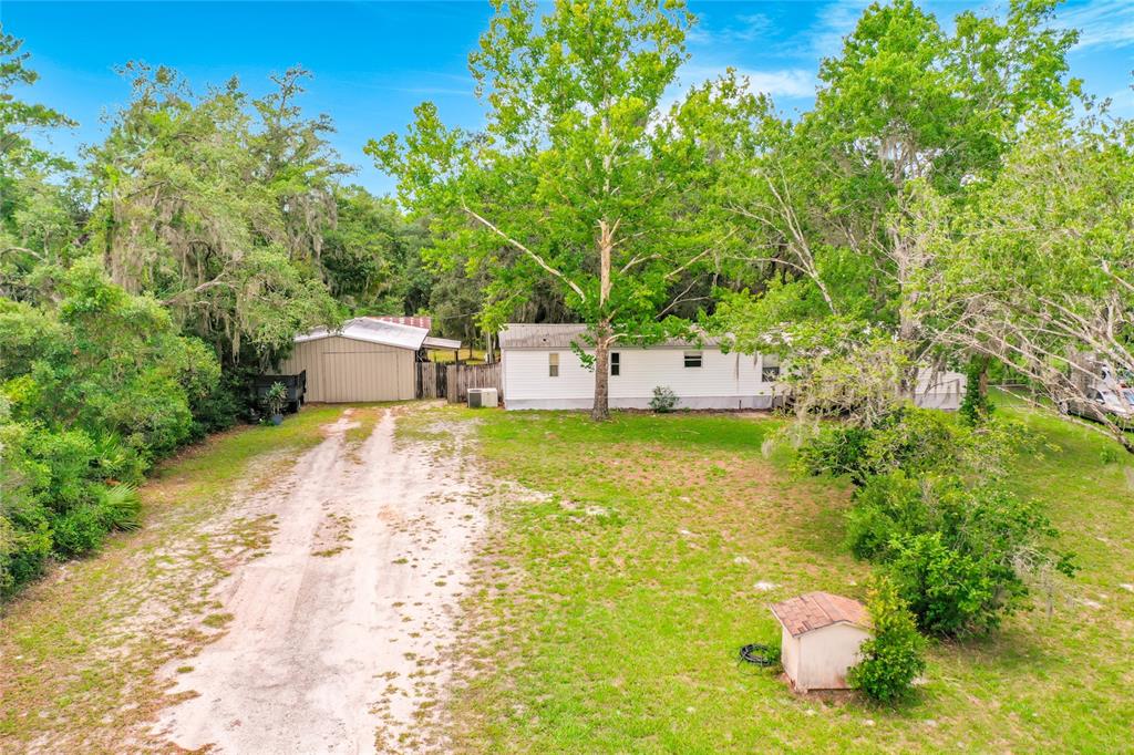 An aerial view shows a mobile home, a detached metal garage, and a small shed — 31032 RORY LANE, EUSTIS, FL