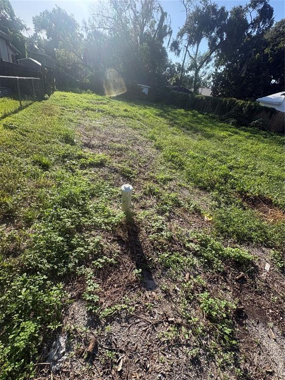 A grassy, vacant residential lot features a single white PVC pipe protruding from the ground — 8312 N KLONDYKE STREET, TAMPA, FL