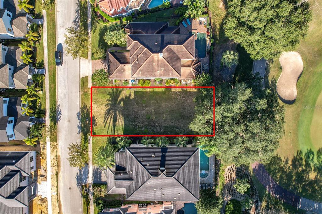 An aerial view shows several large houses situated along a street next to a golf course — 7455 GATHERING DRIVE, KISSIMMEE, FL