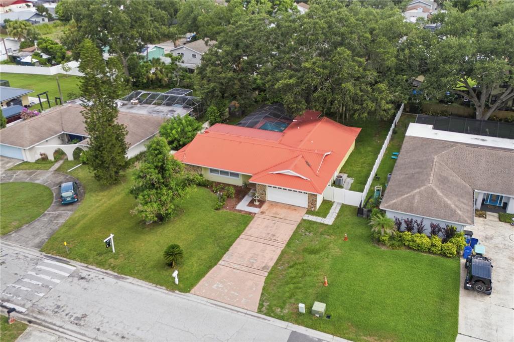 A single-story house with a yellow exterior, stone accents, and a red metal roof — 1514 BURNING TREE LANE, BRANDON, FL