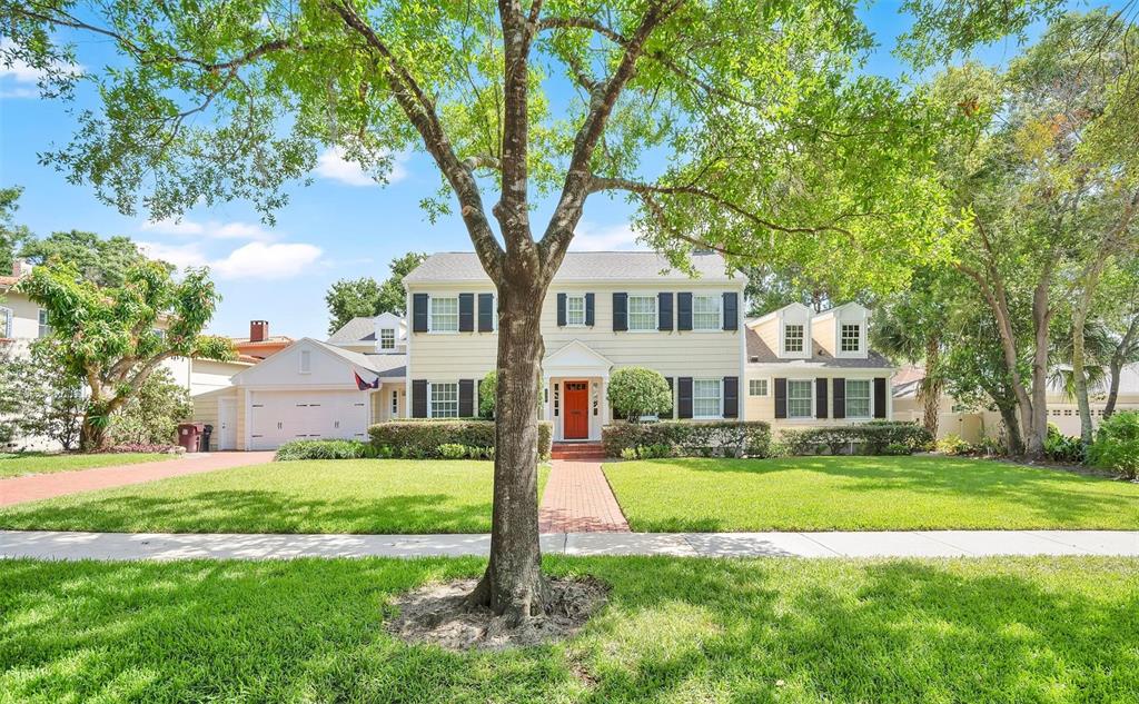A two-story house with light siding, black shutters, and a red front door — 729 ALAMEDA STREET, ORLANDO, FL