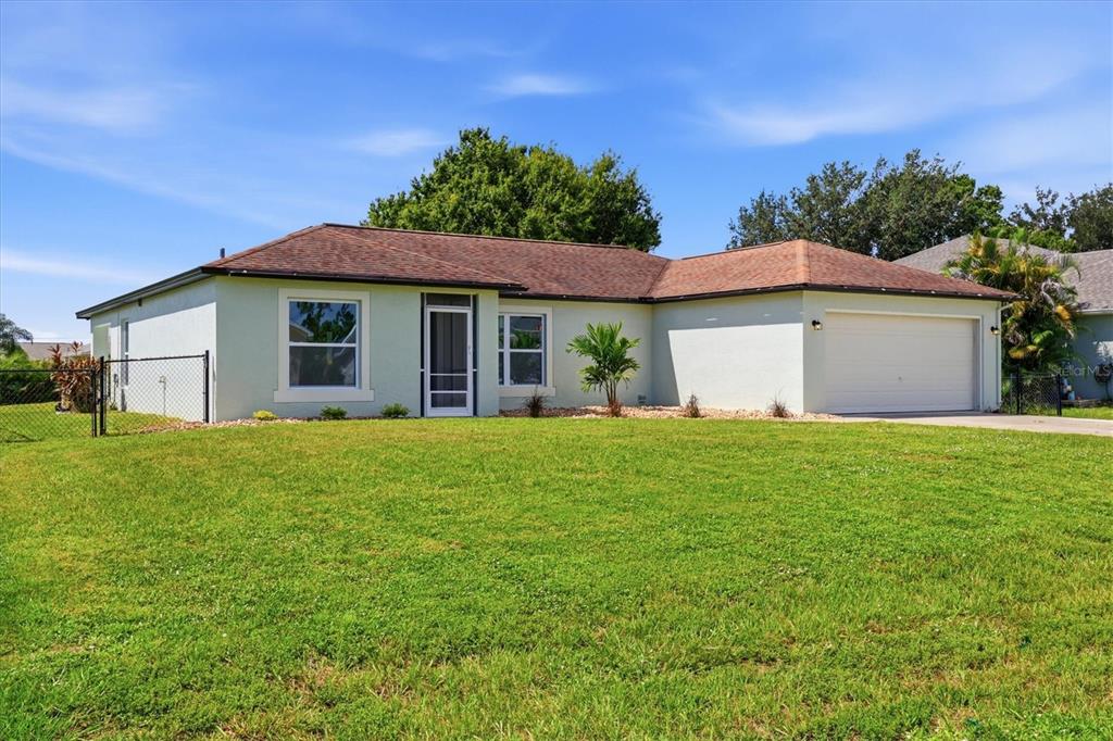 An open-concept living and dining area features light wood flooring, white walls, and modern furniture — 27215 PUNTA CABELLO COURT, PUNTA GORDA, FL