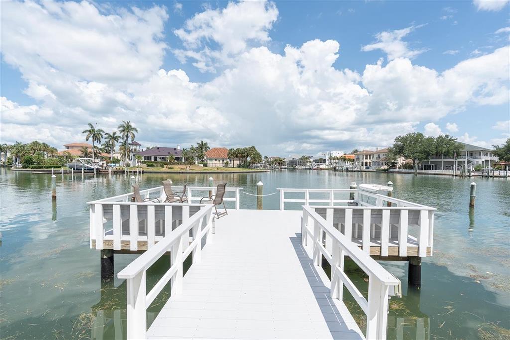 An aerial view shows a multi-story apartment building with a tennis court and parking lot — 719 PINELLAS BAYWAY S UNIT 110, TIERRA VERDE, FL