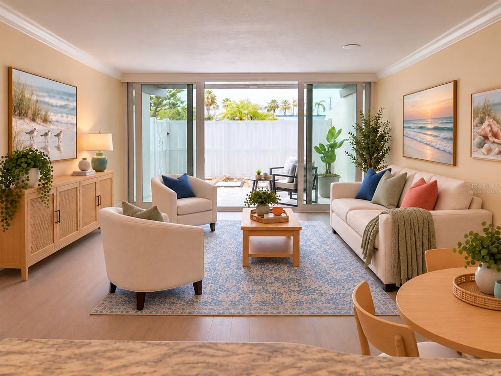 A living room features two cream armchairs, a tiered side table, and sliding glass doors — 450 TREASURE ISLAND CAUSEWAY UNIT 102, TREASURE ISLAND, FL