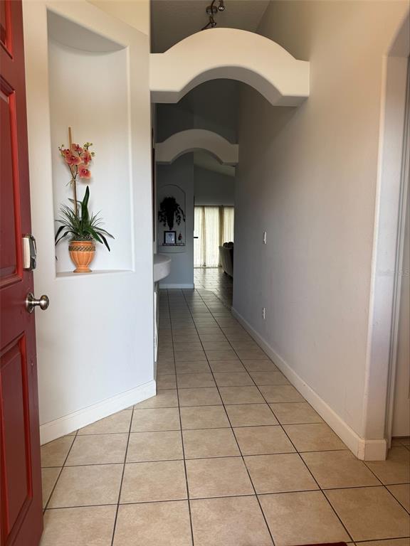 An entryway with tiled floors leads through arched doorways toward a bright living area — 742 OLD BRIDGE CIRCLE, DAVENPORT, FL