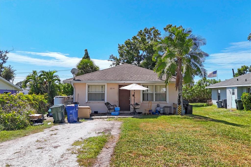 A single-story house with a light-colored exterior, a palm tree, and a gravel driveway — 2214 PARK ROAD, VENICE, FL