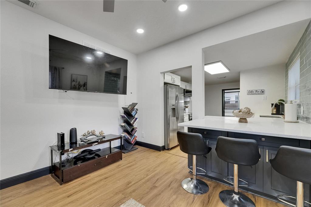 A living area with a wall-mounted television, media console, and a kitchen island with stools — 1009 E COLUMBUS DRIVE, TAMPA, FL