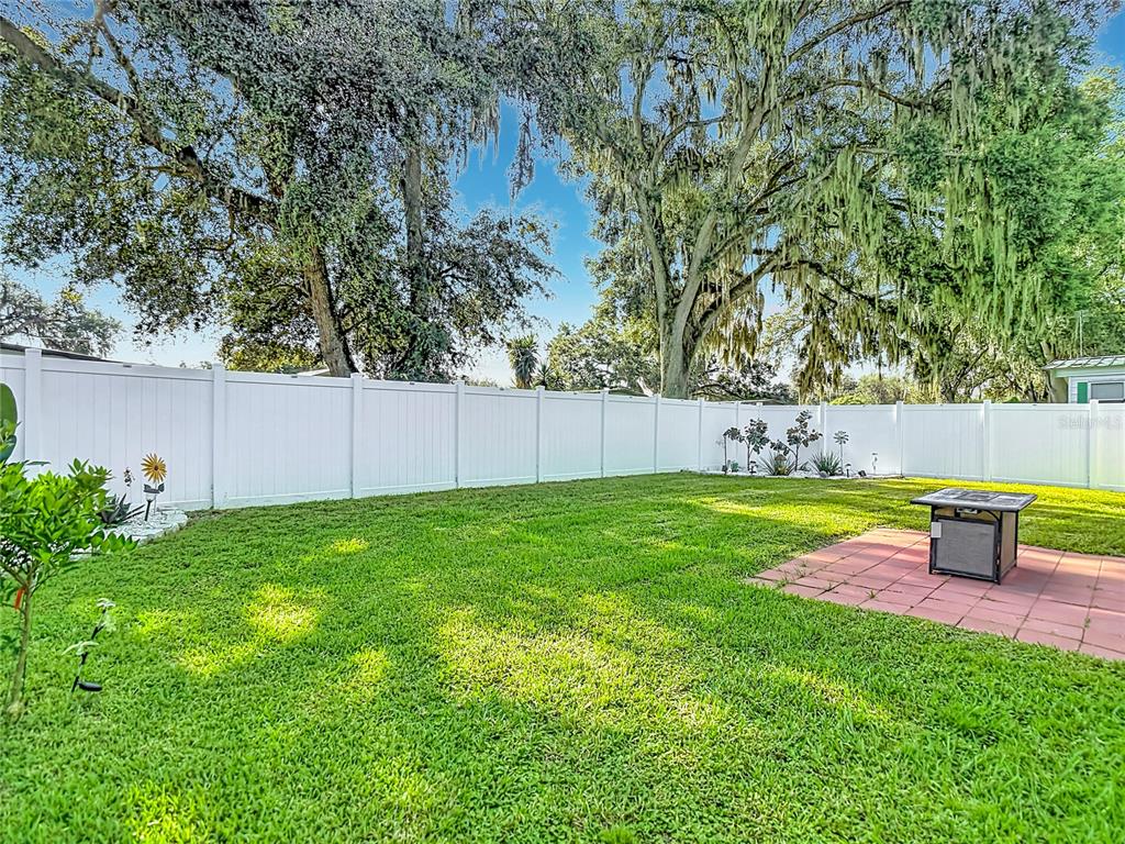 An aerial view shows a house with a metal roof, a fenced yard, and a patio — 4616 OLIVE DRIVE, ZEPHYRHILLS, FL