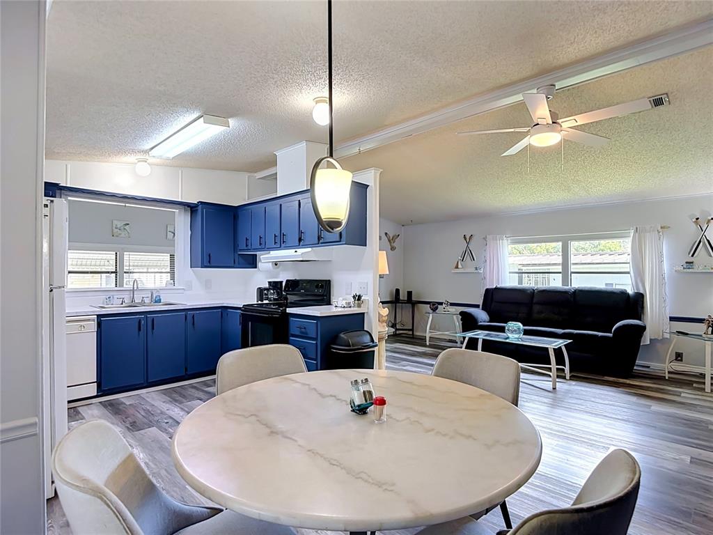 A single-story manufactured home with a carport, front porch, and a landscaped rock garden — 4616 OLIVE DRIVE, ZEPHYRHILLS, FL
