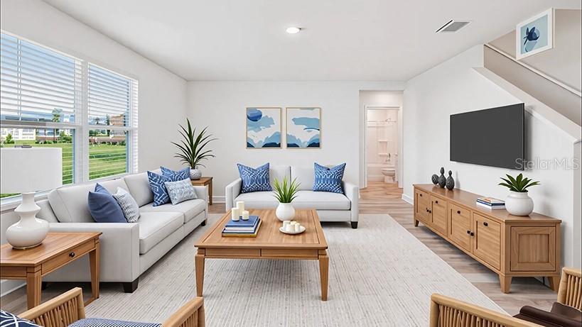This is a digital rendering of a living room with light wood furniture and blue accents — 10182 SE 158TH LANE, SUMMERFIELD, FL