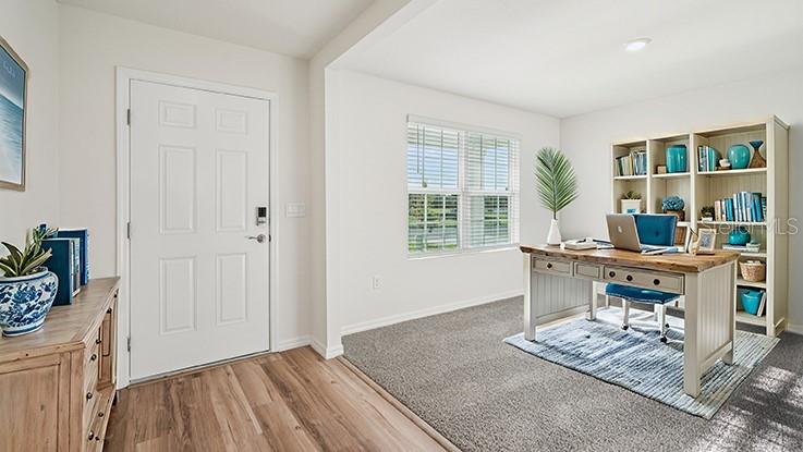 A home office features a white door, a wooden desk, and a tall bookshelf — 10182 SE 158TH LANE, SUMMERFIELD, FL