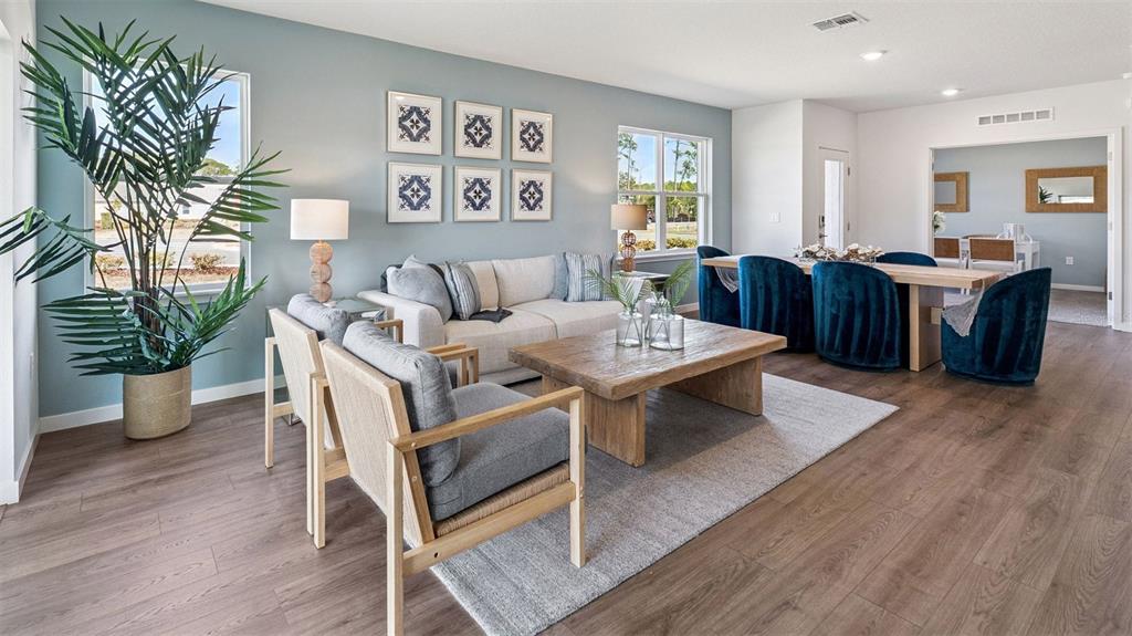 A living room features a light blue wall, wood flooring, and a wooden coffee table — 2516 KINSALE LANE, ORMOND BEACH, FL