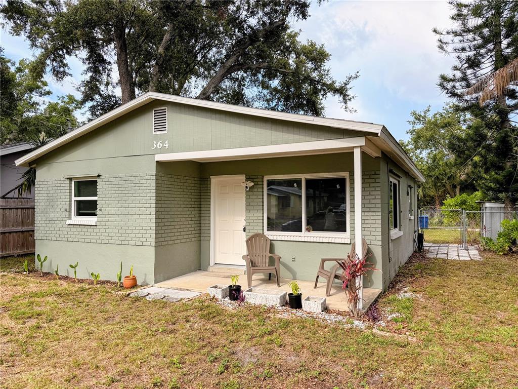 A single-story house with green brick siding, a covered front porch, and two chairs — 364 3RD STREET NW, LARGO, FL