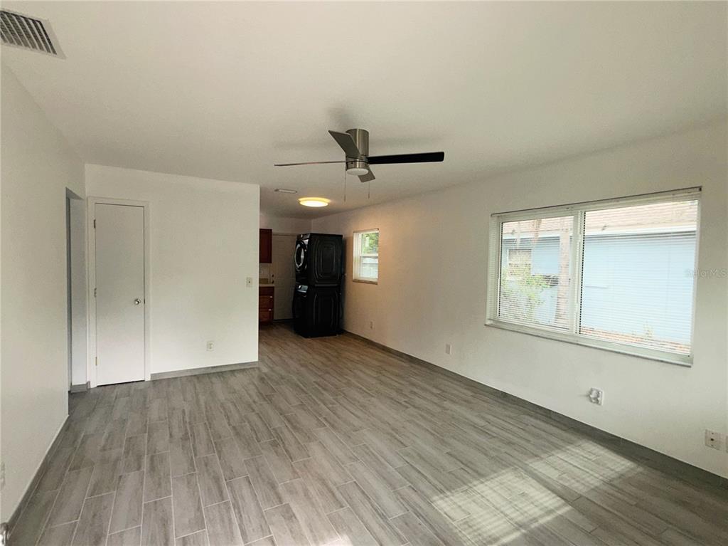An interior view of a room with light wood-look tile flooring and a ceiling fan — 364 3RD STREET NW, LARGO, FL