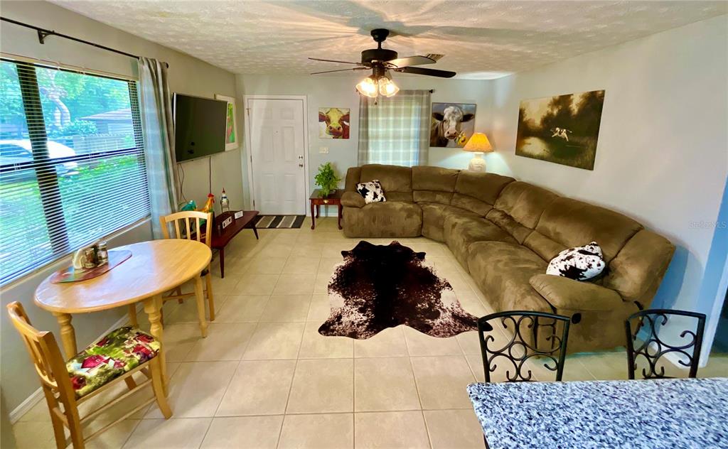 A living room features a brown sectional sofa, a cowhide rug, and a dining area — 468 28TH WAY, MELROSE, FL