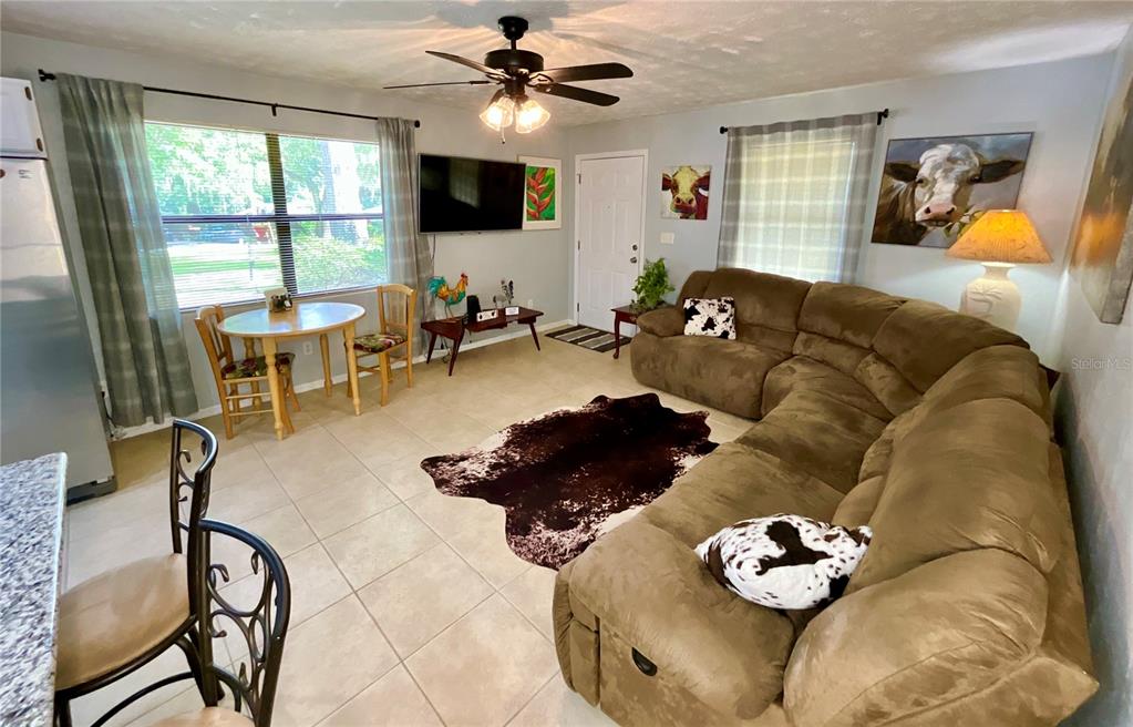 A living room features a brown sectional sofa, a cowhide rug, and a dining area — 468 28TH WAY, MELROSE, FL