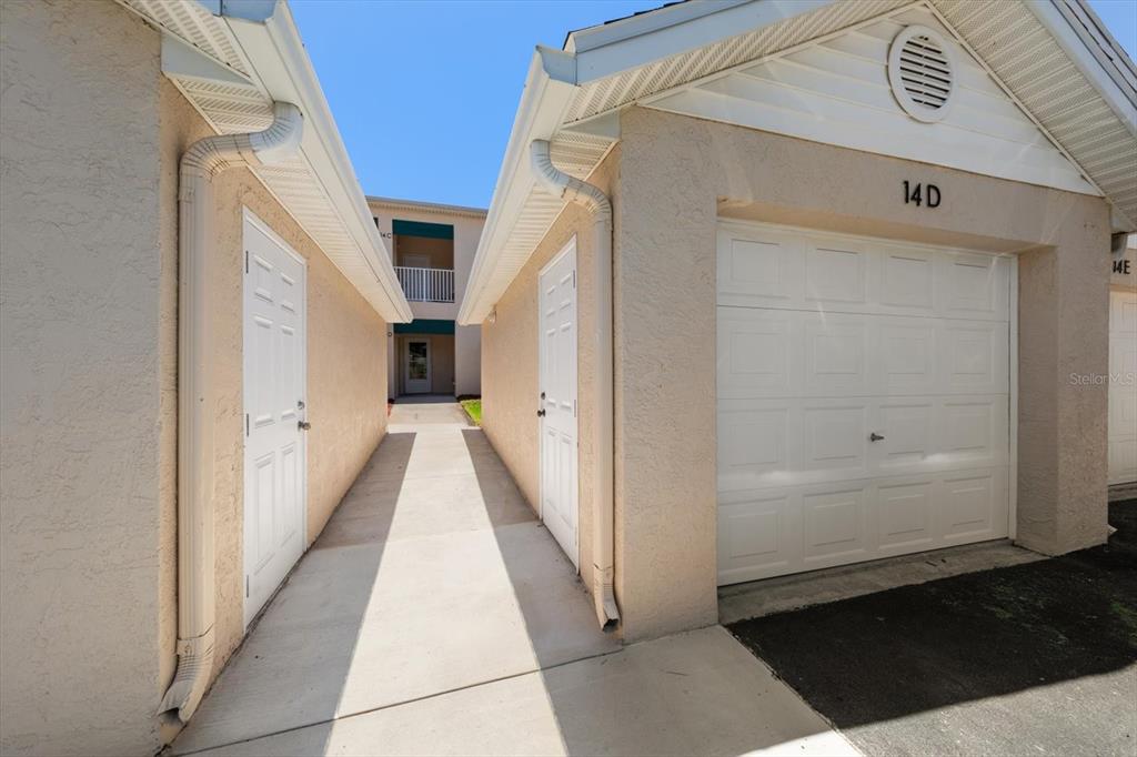 The exterior view shows a ground-level apartment entrance with a covered porch and stairs — 6330 99TH WAY N UNIT 14D, SEMINOLE, FL